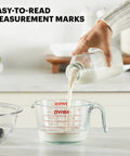 Person pouring milk into 4 Cup Glass Measuring Cup For Baking And Cooking With Easy To Read Ounces And Milliliters, Dishwasher Safe