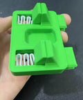 Green nonslip adjustable soldering aid clamp fixture for precise wire welding and soldering jigs, held in hand, side view.