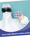Individual in protective suit holding Ten Pack Protection Suit Warning Labels and Adhesive Safety Stickers for Factory Equipment.