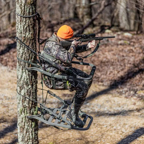 Hunter using Titan Sd Climbing Treestand With Roomier Design Bigger Top Seat Frame And Longer Foot Platform For Large Frame Hunters