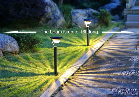 50 Lumen Solar Path Lights 42X Brighter Than Standard Garden Lighting illuminating a path, beam up to 16ft, matte black stakes in lawn