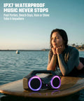 80W Peak Bluetooth Speaker With Bass Boost, Loud As Hell, 20 Hours Of Playtime, IPX7 Waterproof, RGB Lights on surfboard.