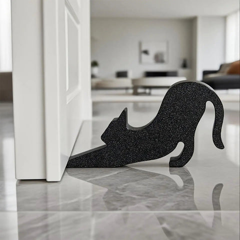 Black Eco Friendly Door Stopper With Soft Impact Absorbing Block shaped like a cat holding a door open on a tile floor