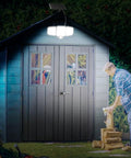 Game Changer Outdoor Solar Flood Lights illuminating a garden shed at night, 3-head design with remote control visible