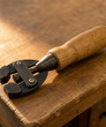 Handheld Adjustable Wire Clamp Tool With Carbon Steel Clamp Head And Screw Control Ultra Lightweight Wood Handle Perfect For Woodworking DIY Projects Detailed Woodcraft Small Parts Holding Benchtop Work Easy Grip on wooden block