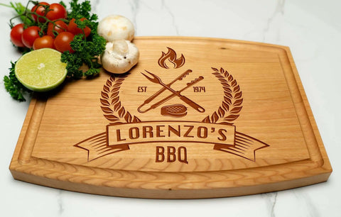 Front view of a wooden cutting board engraved with Lorenzo's BBQ logo, crossed tools; tomatoes and lime on the side.