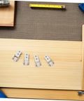 Six Pack Nylon Guide Wheels In Clean White For Furniture Track Systems And Drawer Hardware on wooden surface with measuring tape.