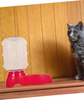 Chill Out As Your Furry Buddies Chow Down On This Pink 3.5L Automatic Pet Feeder And Water Bowl Station Featuring A Tight Leak Proof Cap And Grippy Non Slip Bottom next to a curious cat.