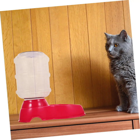 Chill Out As Your Furry Buddies Chow Down On This Pink 3.5L Automatic Pet Feeder And Water Bowl Station Featuring A Tight Leak Proof Cap And Grippy Non Slip Bottom next to a curious cat.