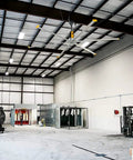 Heavy Duty Portable Evaporative Swamp Cooler With 50 Inch Fan in spacious garage, showcasing 64 gallon tank and work area.