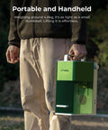 Green XTOOL handheld laser engraver with white carrying handle, side vents visible