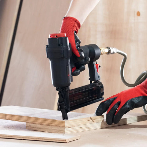 Pro Grade 18 Gauge Pneumatic Brad Nailer And Air Powered 2 In 1 Staple Gun Kit in use on wood, demonstrating sturdy build and smooth firing action.