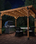Ironwood Lite 8x8 Post Base Kit securing wood pergola over patio with grill and seating area, showcasing decorative plates and hex cap nuts
