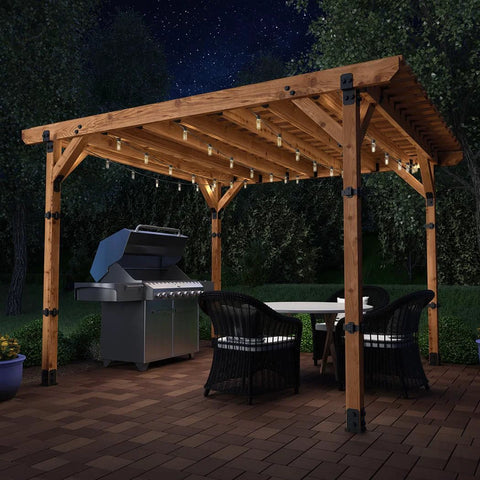 Ironwood Lite 8x8 Post Base Kit securing wood pergola over patio with grill and seating area, showcasing decorative plates and hex cap nuts