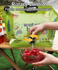 All Day Hydration On Tap Large Capacity Camping Water Container dispensing water into a bowl of red grapes on a table.