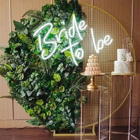 Bride To Be Neon Sign Led Light For White Wedding Party Bar Wall Decor Bedroom Or Living Space With Soft Glow For A Dope Vibe At Bachelorette Parties Engagements Birthdays Or Special Occasions on a green background with cake and macarons.