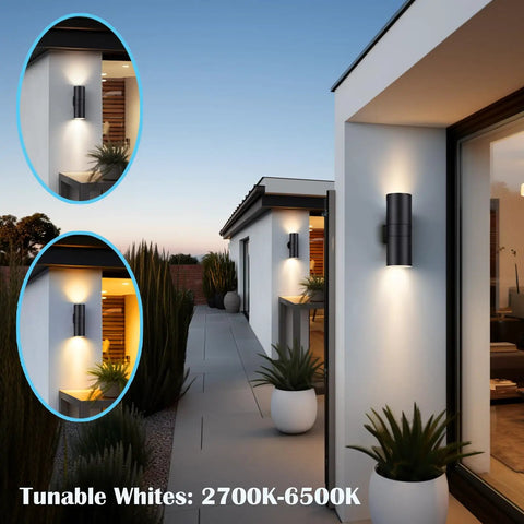 Exterior Up Down Outdoor Wall Lights With Remote Control RGB Color Changing 1200 Lumen Warm White 3000K RGB CCT Cylinder Outdoor LED Lighting 2 Pack Weatherproof IP65 Rated For Outdoor Use illuminating a modern patio with plants during sunset.