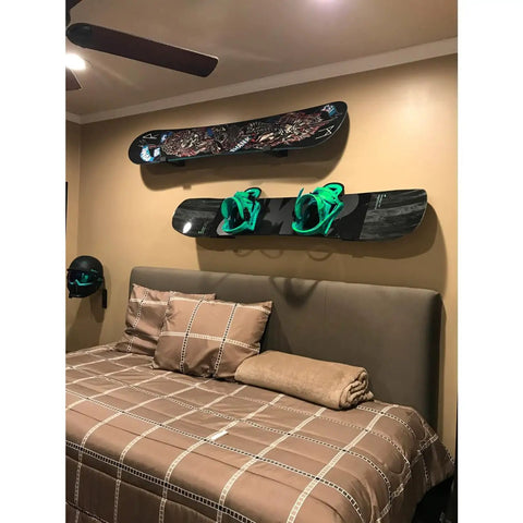 Rock Hard Premium Aluminum Snowboard Wall Mount Rack With Grippy Eva Padded Skis Display Hanger For Garage Home Storage Heavy Duty Brackets Double Pack Set on bedroom wall with snowboards and green bindings.