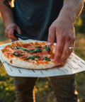 Person using 14 Inch Perforated Pizza Peel With Long Handle Aluminum Lightweight Pizza Paddle For Turning And Lifting Pizza