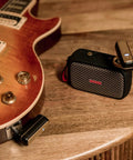 Wireless Guitar System With Rock-Solid 2.4G Transmission, 24-Bit/48kHz Audio on electric guitar and receiver on table.