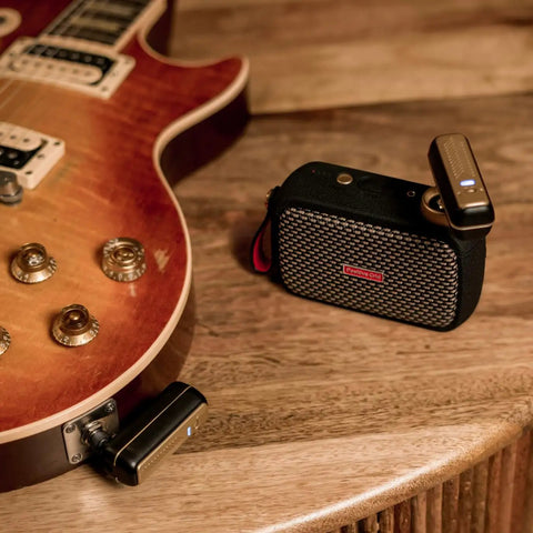 Wireless Guitar System With Rock-Solid 2.4G Transmission, 24-Bit/48kHz Audio on electric guitar and receiver on table.