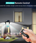 Outdoor scene with hand holding remote, controlling Solar Outdoor Lights 3 Head Motion Sensor Flood Light, 2500LM, on house wall