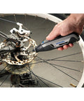 User operating Ultra Compact Four Volt Cordless Rotary Tool Featuring Variable Speed And No Sweat Accessory Swaps for bike repair.