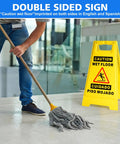 2 Pack Must Have Fold Out Wet Floor Sign Set, 17.5 Inch High Yellow Caution Signs, Double Sided Bilingual Safety Notice With Bold Black Text, Slippery Floor Warn situated next to a mopping action.