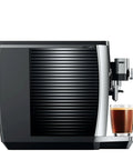 Premium Fully Automatic Chrome Espresso Coffee Machine Featuring A Hella Smooth Four Point Three Inch Smart Touchscreen Display For Twenty Seven Freshly Ground Drinks, side view with cup.