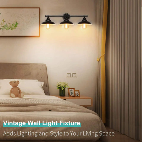 Industrial Rustic 3 Light Vanity Wall Sconce in Dark Bronze with Vintage Gold Trim illuminating a cozy bedroom with bed, artwork, and decor