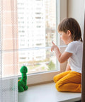 Child sitting by window secured with 4 Pack Adjustable Sliding Door Security Bars With White Rubber Tips Tension Rods 9.8 To 15.7 Inch