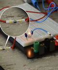 Close-up of Heavy Duty Solder Seal Wire Connectors 100 Pack, waterproof terminals used in a breadboard setup with wires.