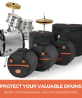 Road Tough Full Size Five Piece Drum Case Set With Killer Thick Padding For 10 Inch 12 Inch Toms 14 Inch Snare 16 Inch Floor Tom And 22 Inch Bass Drum Bags, durable black bags beside a silver drum kit.