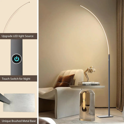 Arc Corner Floor Lamp With 3000K Warm White Cozy Vibes Mood Lighting, Three Brightness Presets, Easy Tap Touch Switch, 63 Inch Curved LED Standing Lamp For Living Room And Bedroom, Sleek Silver Finish next to modern chair and table.