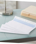 White 100 Pack Self Seal Envelopes With Peel And Seal Privacy Protection for letter size mail on glass desk
