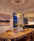 Hodevimall 19.6" Boho Rattan Pendant Light Fixture illuminates a dining room with elegant shadows and rustic decor.