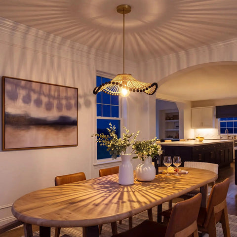 Hodevimall 19.6" Boho Rattan Pendant Light Fixture illuminates a dining room with elegant shadows and rustic decor.