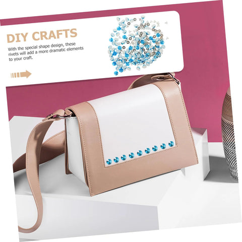 Crossbody bag with beige faux leather and white front panel, blue metal stud trim along bottom.