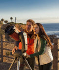 Couple using NexStar 6SE Computerized GoTo Telescope Bundle With Tabletop Tripod And Accessories by the seaside