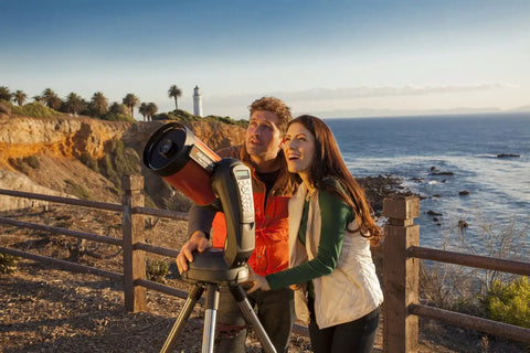 Couple using NexStar 6SE Computerized GoTo Telescope Bundle With Tabletop Tripod And Accessories by the seaside