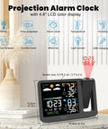 Projection Alarm Clock With Weather Station And Ceiling Projector For Bedroom Readouts Of Indoor Outdoor Temperature And Humidity Plus Auto Dim Backlight And WWVB Atomic Time Display on a table