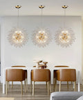 Gold 12 Light Modern Crystal Firework Chandelier With Dandelion Burst Design in dining room with white table and brown chairs