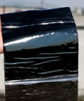 Beat The Elements With This Heavy Duty Roof Underlayment Roll And Bitumen Waterproofing Membrane Self Adhesive Flashing Tape glistening black roll held up.