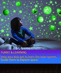 Child gazing at glow in the dark stars and planets ceiling decals for bedroom and living room space wall stickers with solar system planets ideal gift for kids toddlers boys and girls cool night sky decor.