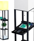 Modern Dimmable Solid Wood Floor Lamp With Shelf And Drawer Two USB Ports And Two Power Outlets Super Handy Corner Tall Bookshelf Lamp For Living Room And Bedroom Black Finish featuring a glowing lamp, shelves with books and plant, and charging devices visible.
