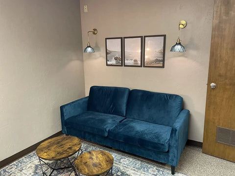 Battery Powered Wall Sconce Set Of 2 With Remote No Wiring Needed Wireless Indoor Lights Featuring Dope Blue Glass Shade Vintage Vibe Style Hanging Wall Lighting Fixture For Bedroom Living Room Bathroom Hallway And More Decor illuminating a cozy room with blue sofa and round wooden tables.