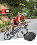Cyclist using Speed And Cadence Sensor Bundle with Bluetooth 5.0 and ANT Plus on mountain road, displaying 93 rpm reading.