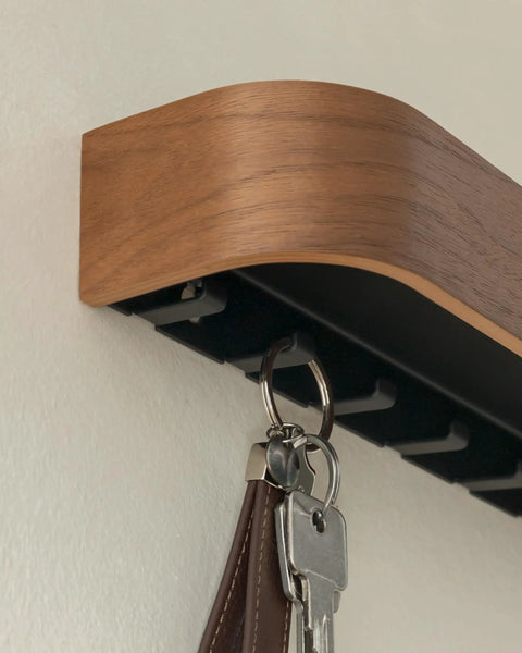 Side view of walnut wall mounted key holder with wooden shelf, showing six slick hidden hooks for keys.