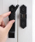 Hand operating 180-degree black barn door lock with handle on white door, part of Pack Of 3 180 Degree Black Barn Door Locks And Latches With Handle For Cabinets Bathroom Closet Window Garage Security Lock Set Heavy Duty Sliding Door Latch.