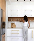 Brushed Gold Cabinet Pulls 12.6 Inch 6 Pack visible on modern kitchen cabinets with woman reaching for glass.